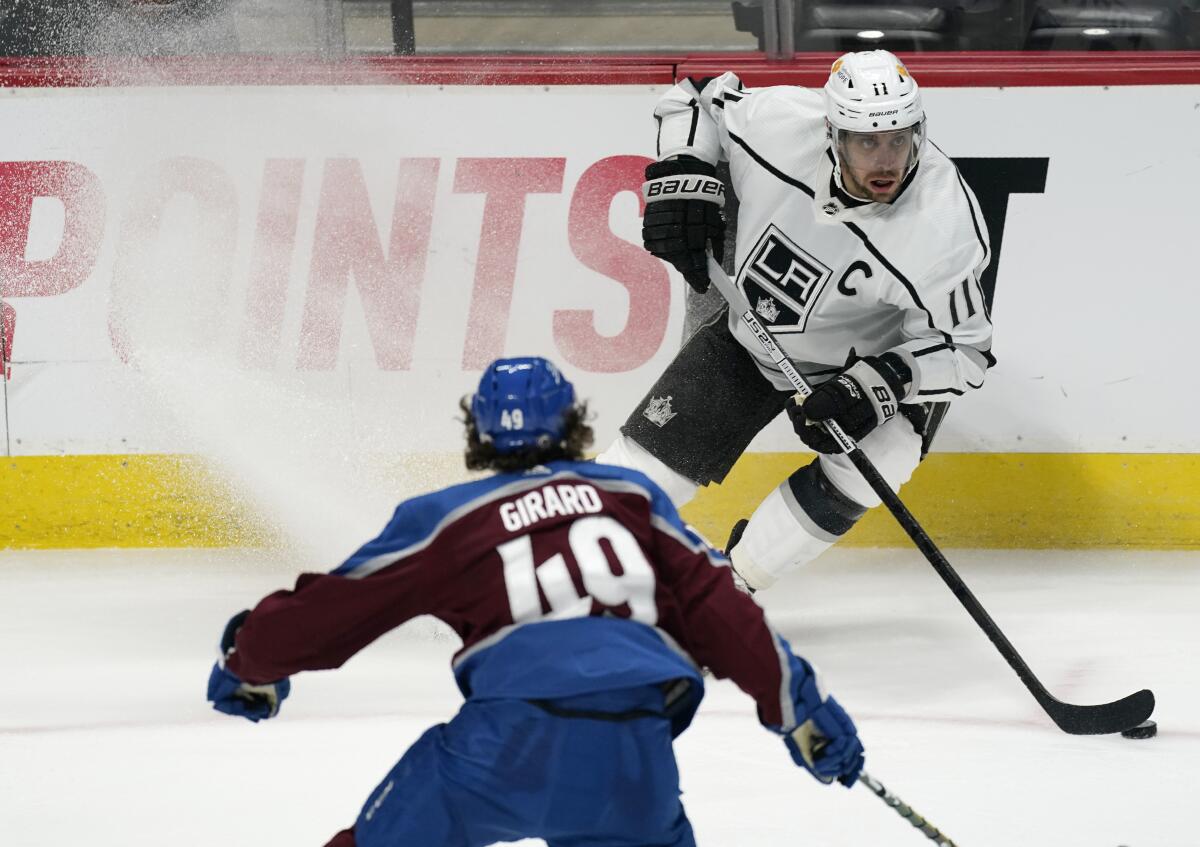 Kings center Anze Kopitar looks to pass in front of Colorado Avalanche defenseman Samuel Girard.