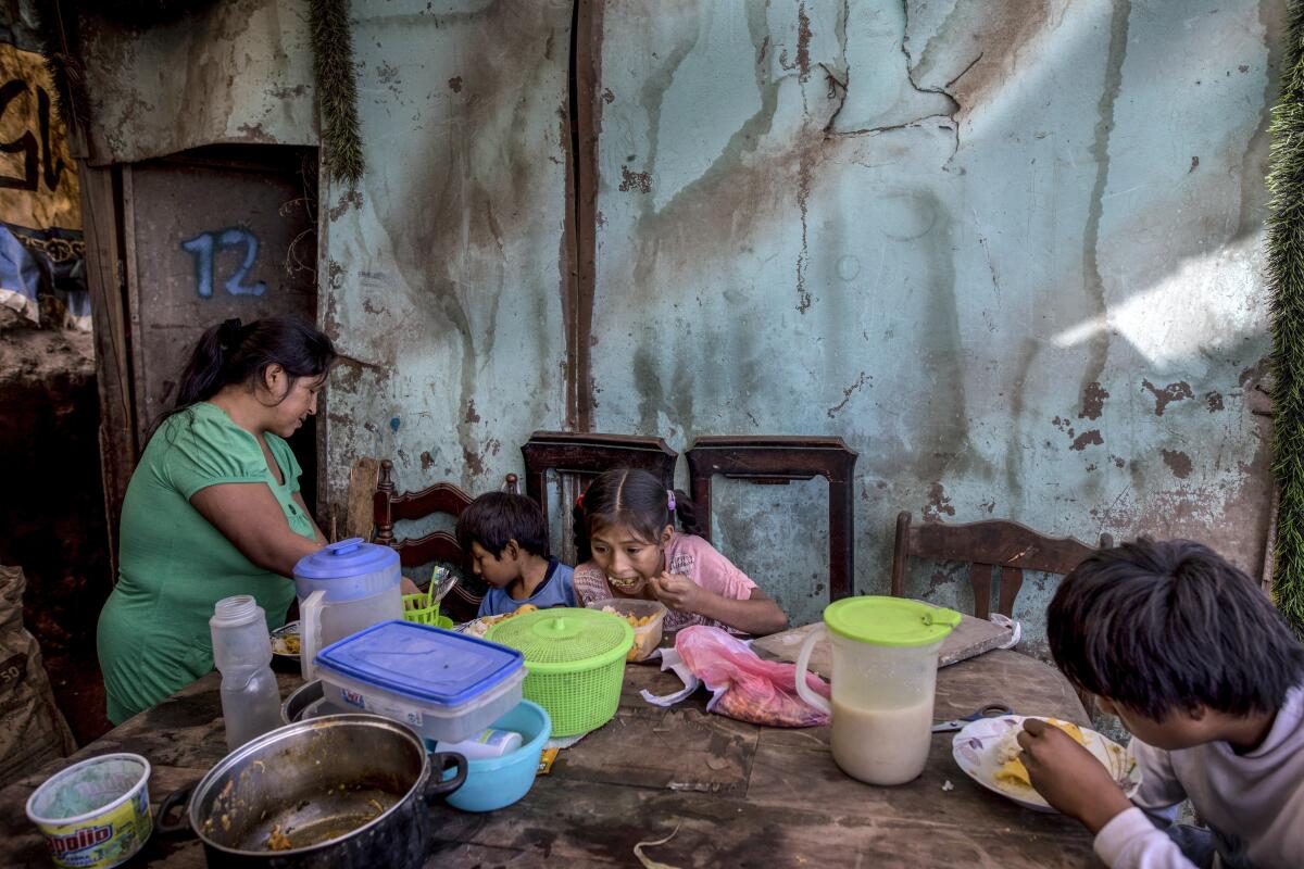 Consuelo Pascacio's three children dig into a chicken rice stew she picked up at a "community pot" in  Lima, Peru.