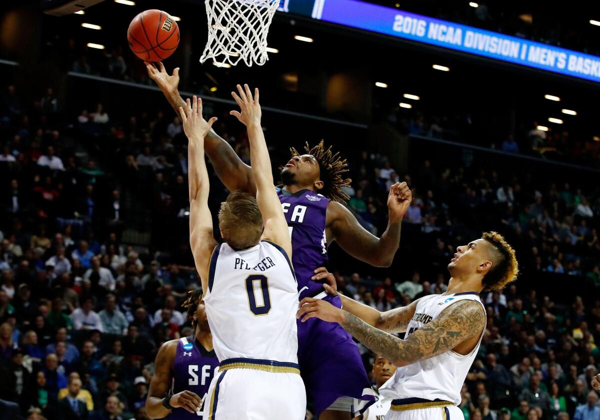Stephen F. Austin's Clide Geffrard Jr. shoots against Notre Dame's Rex Pflueger (0) during the second half of a game on Sunday.