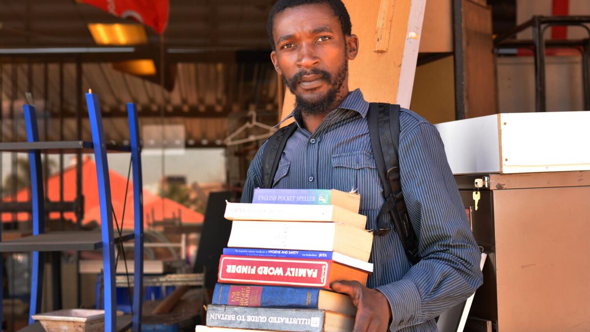 Sandile Mavimbela sells books from his makeshift sidewalk shop in Johannesburg, South Africa.