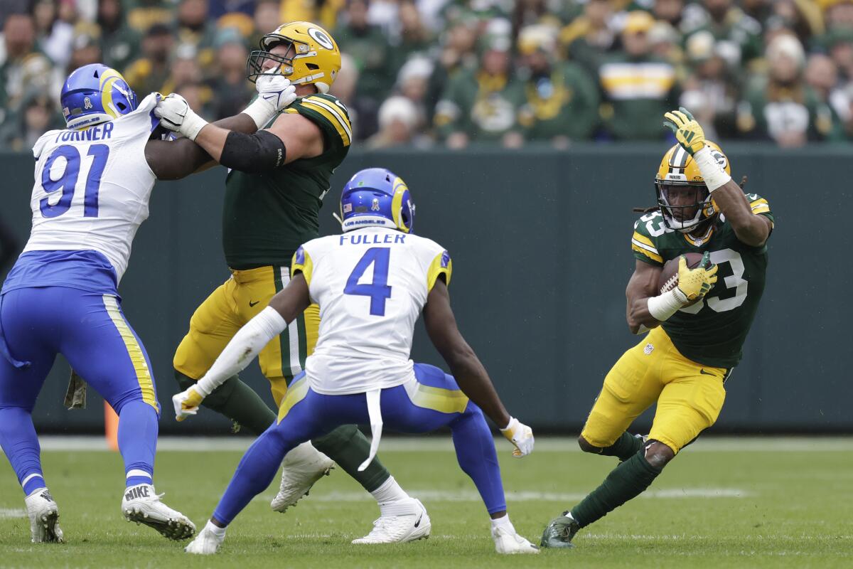 Green Bay Packers running back Aaron Jones, right, carries the ball during the first quarter.