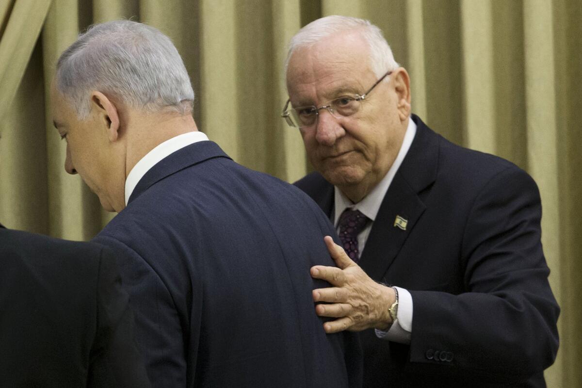 Israeli President Reuven Rivlin, right, escorts Prime Minister Benjamin Netanyahu after a brief ceremony in the president's residence in Jerusalem on Monday. Netanyahu has received a two-week extension to form a new governing coalition following his election victory last month.