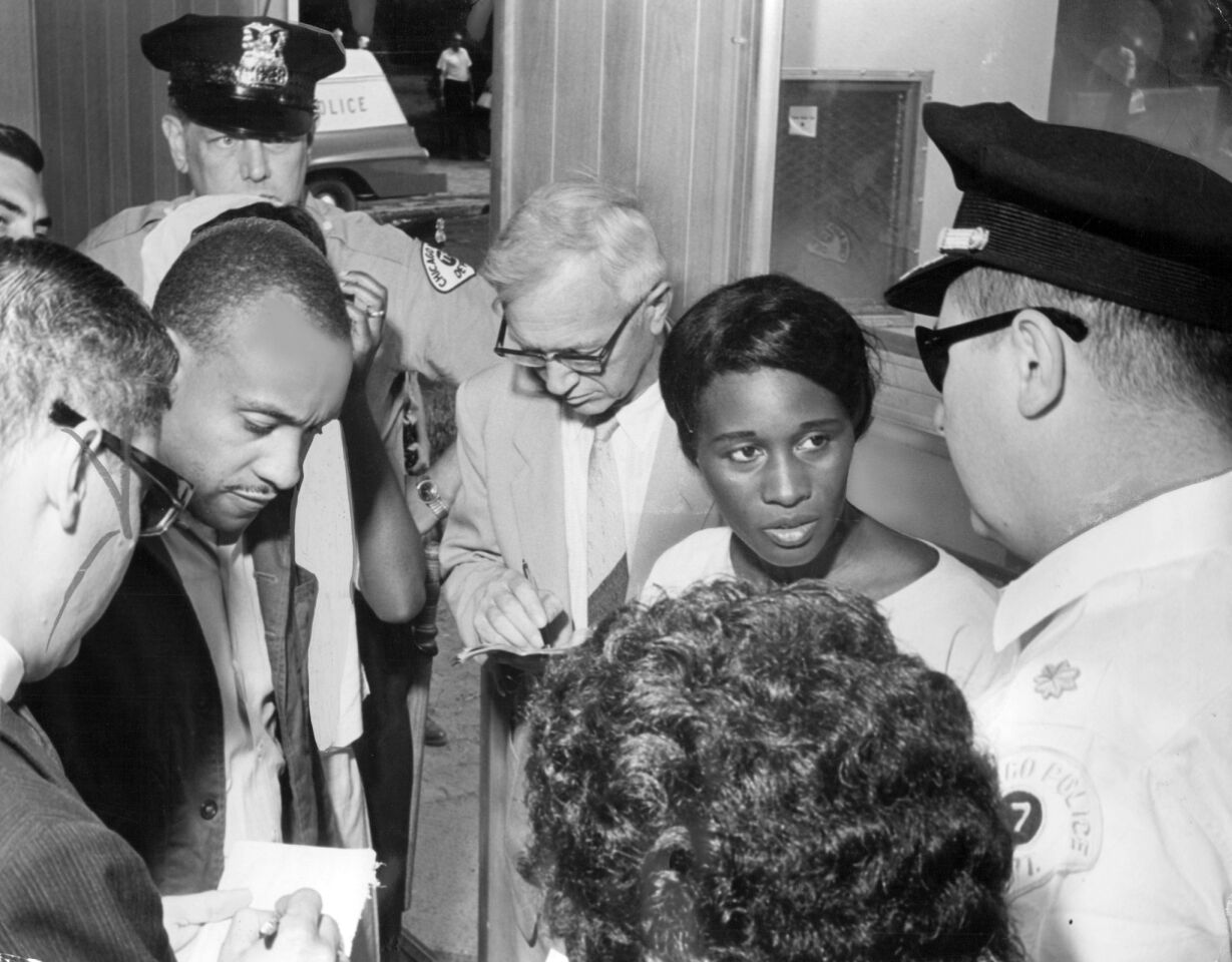 Congress of Racial Equality leader Charles Smith, second from left, and Parent Committee President Rosie Simpson, second from right, seek permission from Chicago police Capt. William McCann, right, to hold a prayer meeting at a mobile school site at 73rd Street and Lowe Avenue on Aug, 16, 1963. McCann told them they would need a permit from the Chicago Board of Education, and when none was issued, they held a kneel-in anyway.