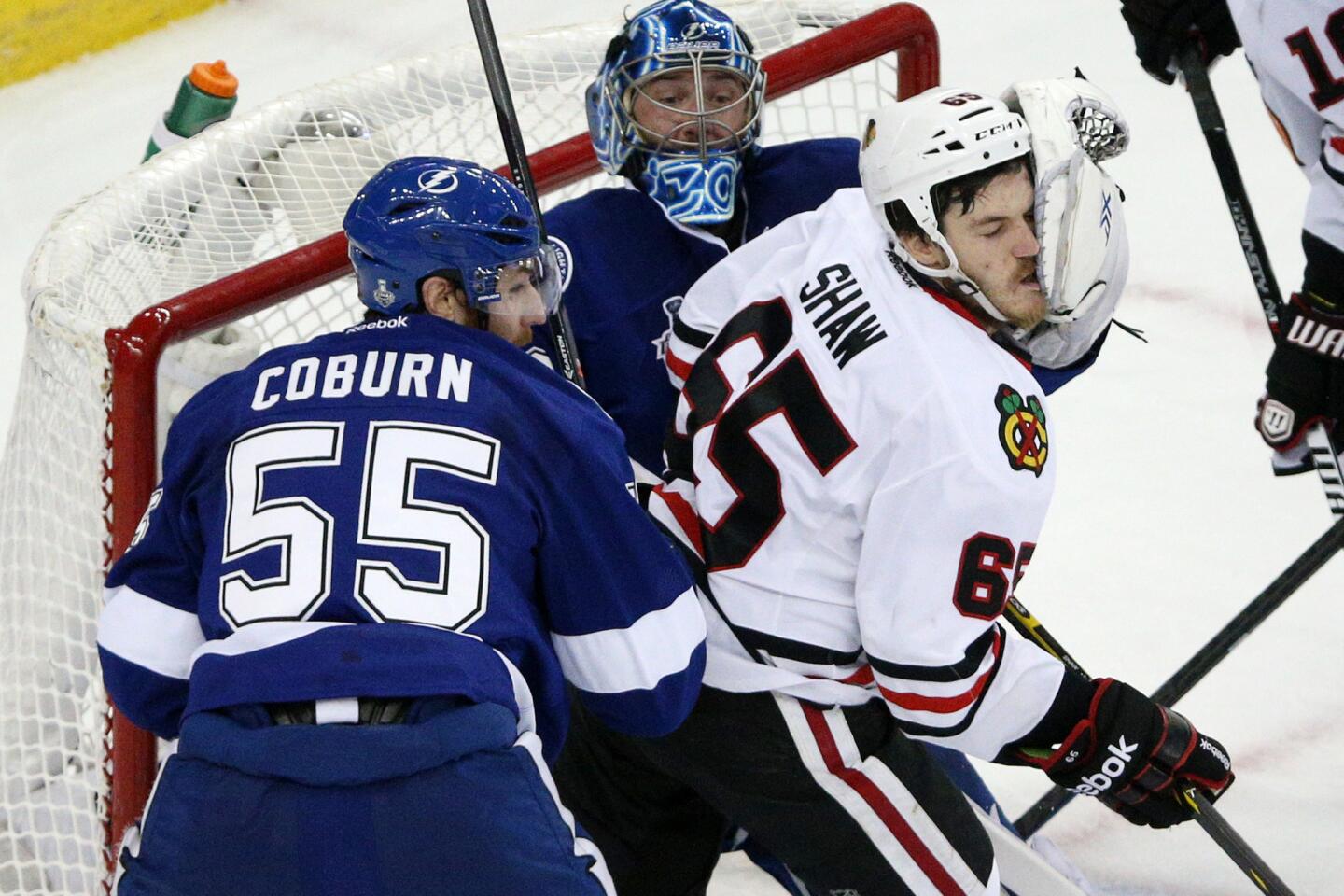 Lightning goaltender Ben Bishop smacks Andrew Shaw in the face with his glove during the second period.