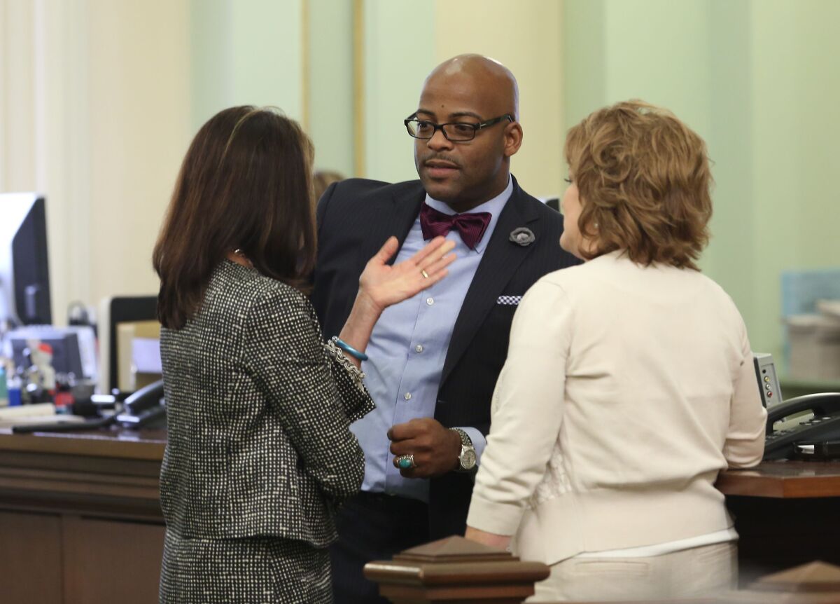 Then Assemblyman Isadore Hall III (D-Compton), center, speaks with GOP Assembly members Diane Harkey of Dana Point, left, and Shannon Grove of Bakersfield on the Assembly floor in April 2014.