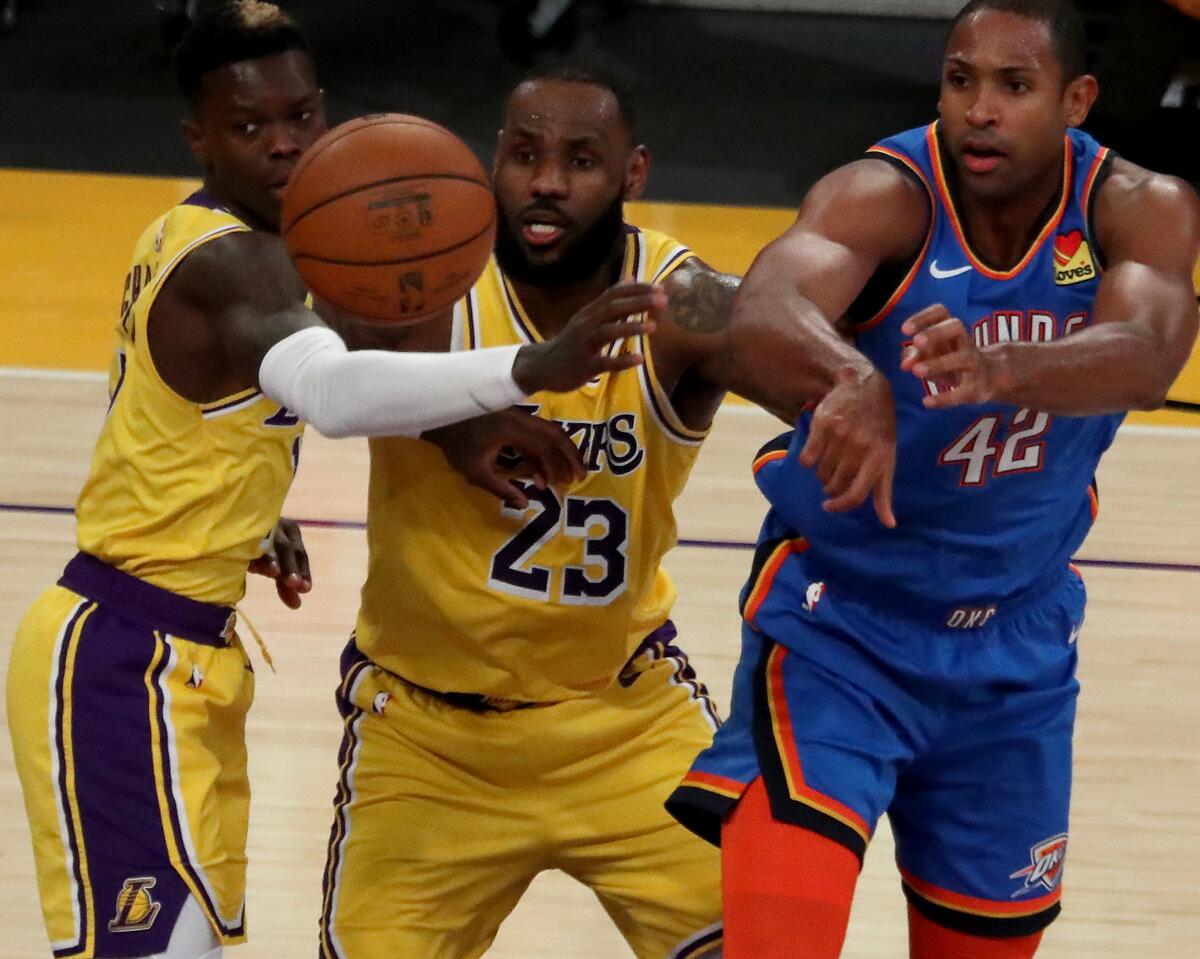 Lakers defenders Dennis Schroder, left, and LeBron James pressure Thunder big man Al Horford in overtime.