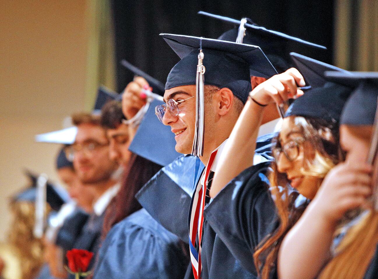 Graduating Daily High School senior Aram Baghdasaryan smiles to the audience after turning his tassel as a symbol of graduating at the graduation ceremony for Daily High School and Verdugo Academy at First United Methodist Church in Glendale on Monday, June 10, 2019.