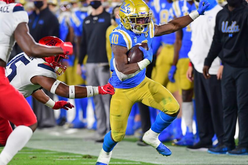 PASADENA, CA - NOVEMBER 28: Running back Demetric Felton #10 of the UCLA Bruins is just out of the reach of defensive back McKenzie Barnes #15 of the Arizona Wildcatsas he gains a first down in the first half of the game at the Rose Bowl on November 28, 2020 in Pasadena, California. (Photo by Jayne Kamin-Oncea/Getty Images)