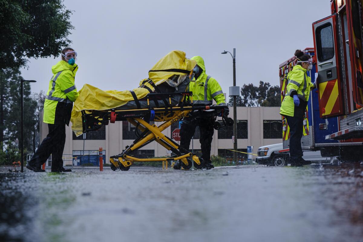 EMTs transport a patient who has COVID-19 symptoms at a Chula Vista hospital.