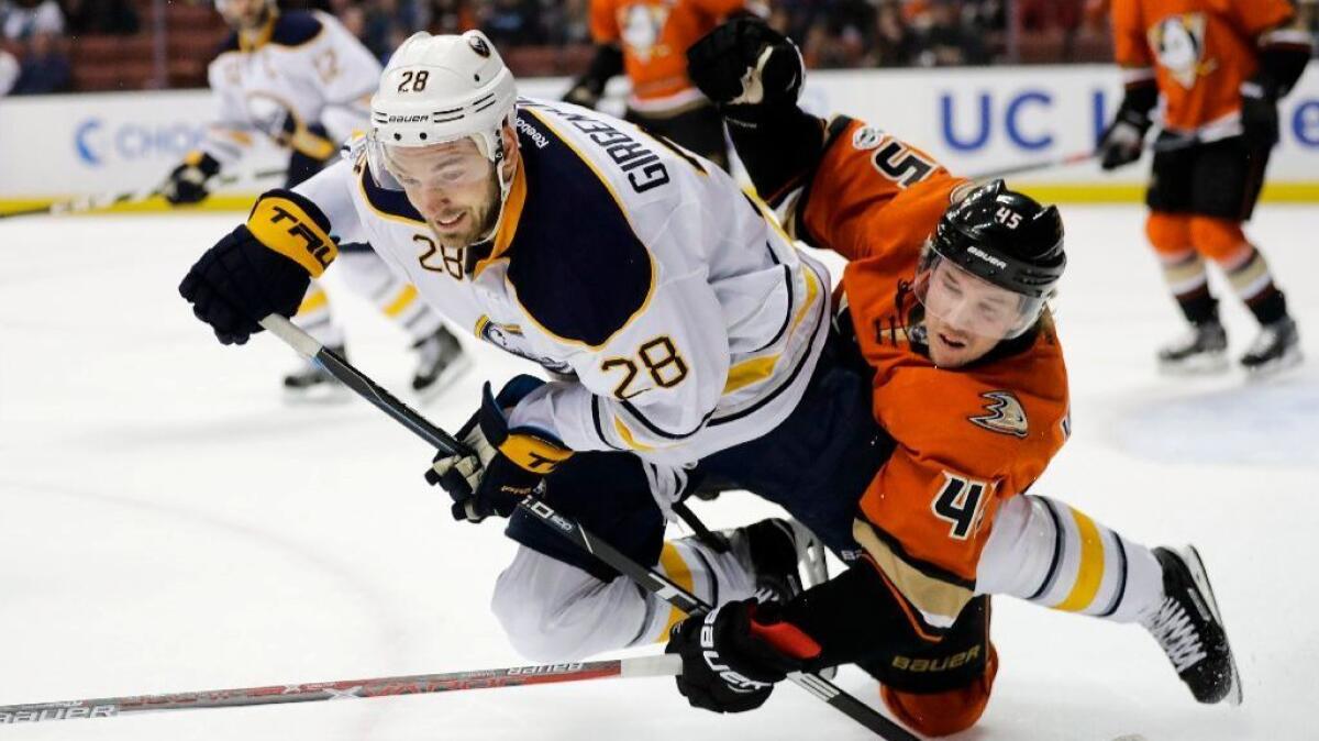Sabres center Zemgus Girgensons and Ducks defneseman Sami Vatanen get tangled up as they compete for the puck during the first period of a game on March 17 at Honda Center.