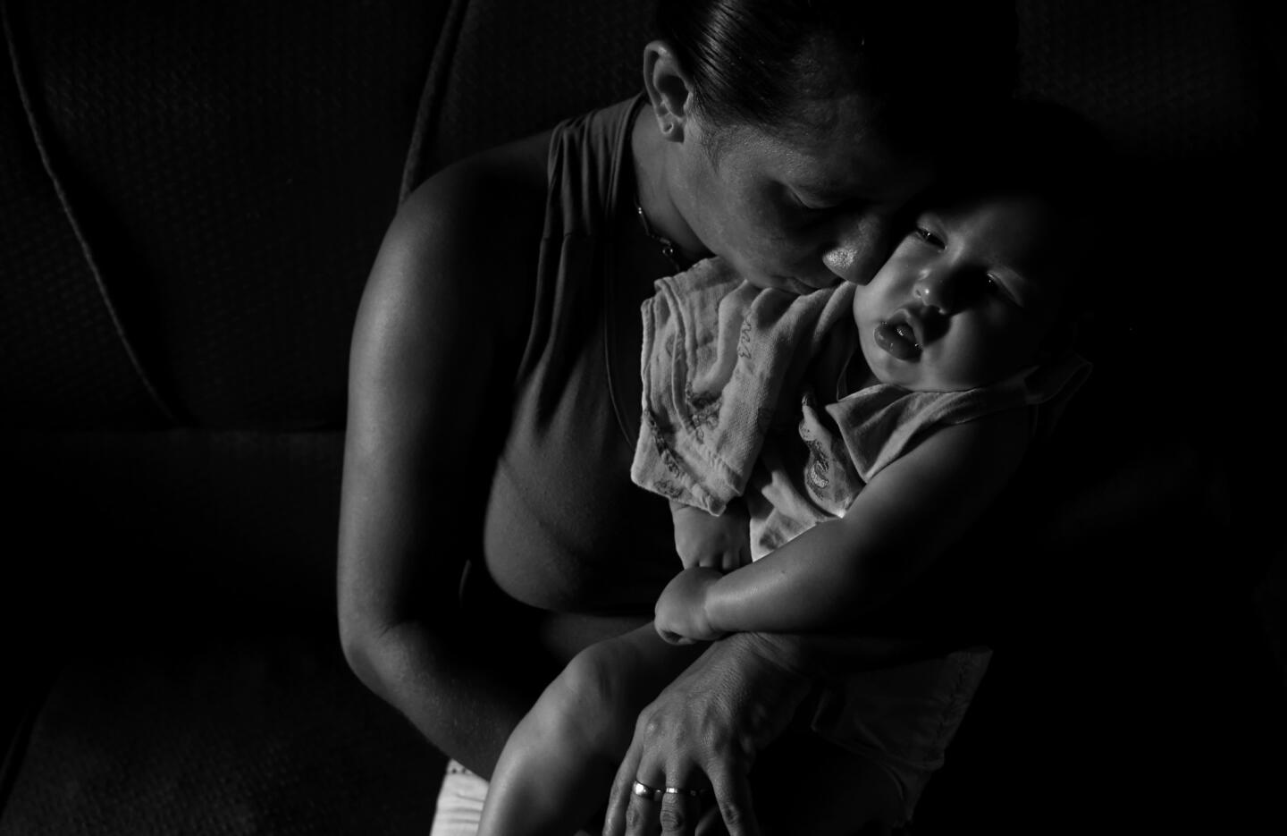 Josemary Gomes cradles her 4-month-old son, Gilberto, in March. "I am Gilberto's father now," she says.