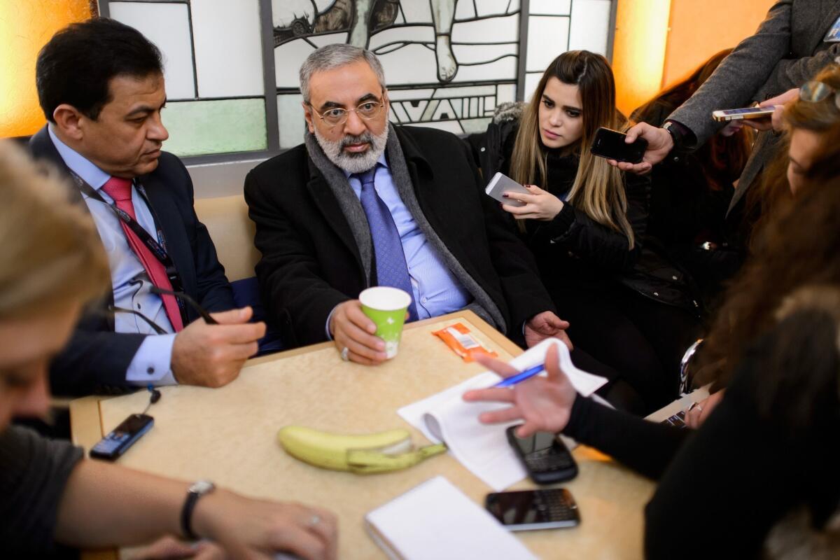 Syrian Information Minister Omran Zoubi answers journalists' questions as he takes a break from the peace talks in Geneva.