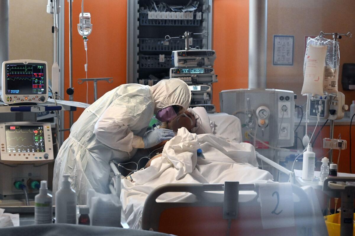A medical worker in protective gear tends to a COVID-19 patient in the intensive care unit of a hospital near Rome.