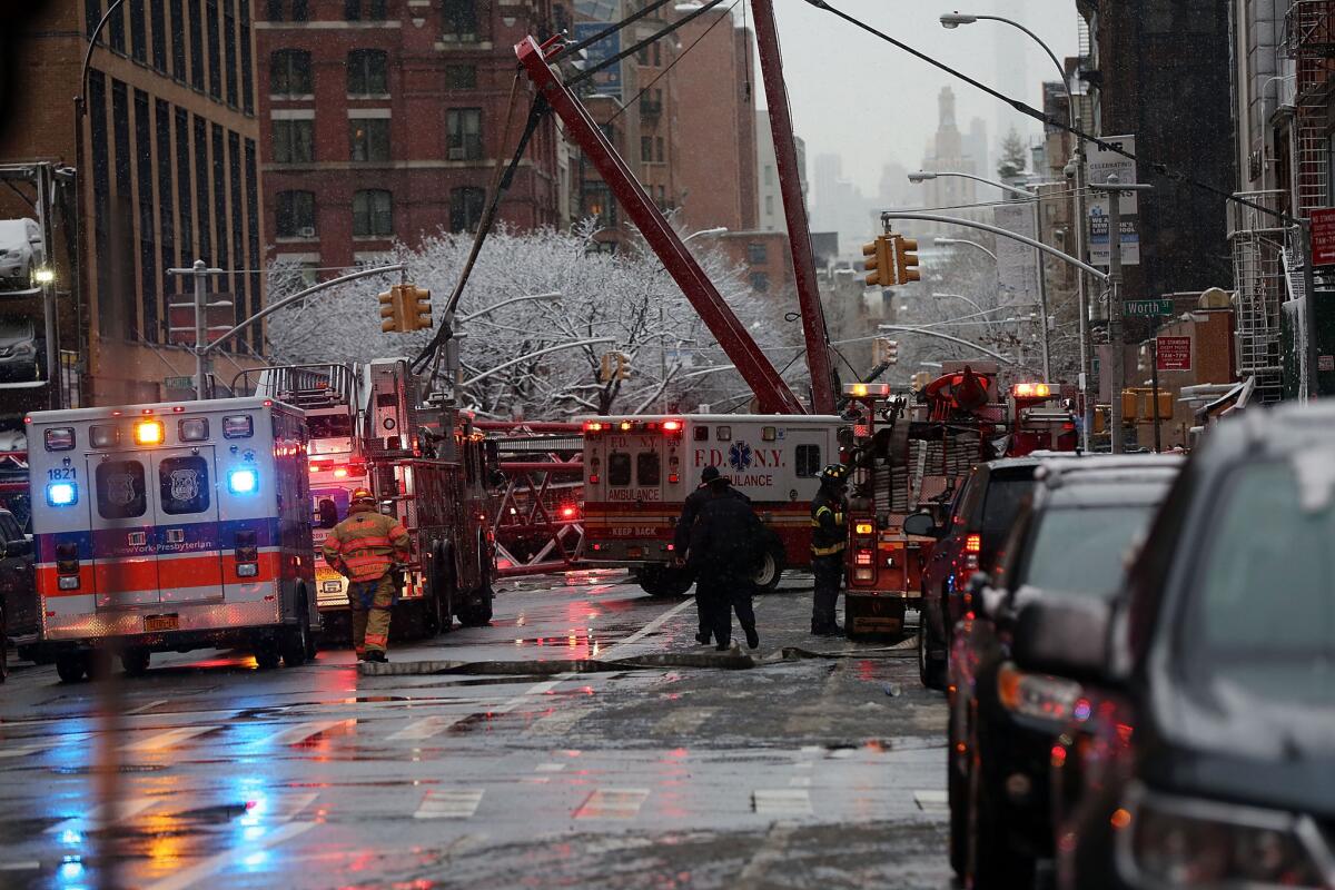 Emergency workers converge at the scene of a collapsed crane in a roadway in lower Manhattan early Friday.