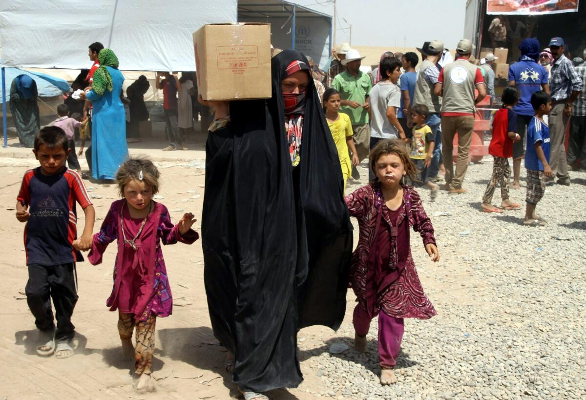 Iraqi families displaced by fighting in their hometowns receive humanitarian aid at the Khazir refugee camp in northern Iraq on July 23.