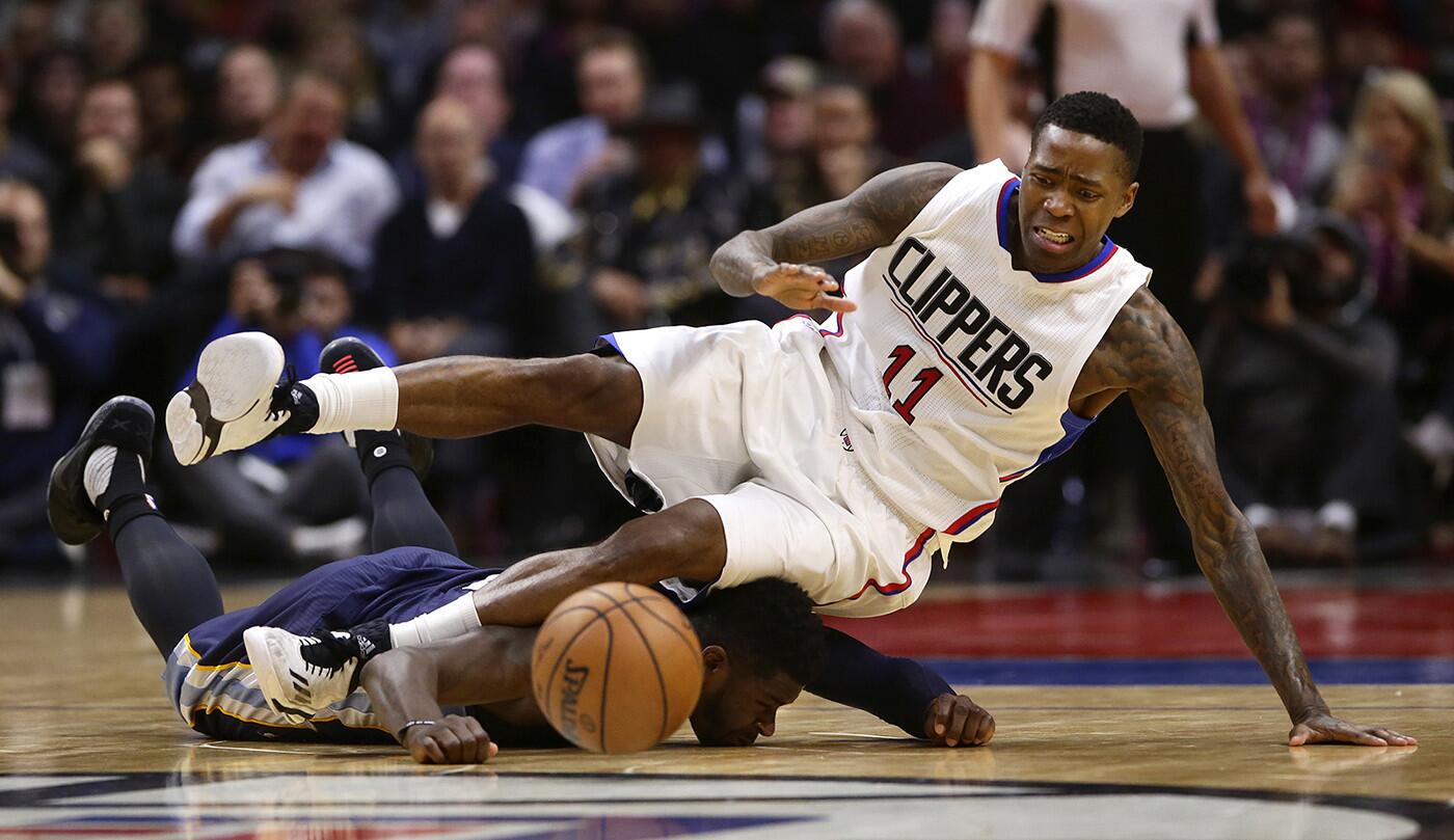 Clippers guard Jamal Crawford falls on Memphis Grizzlies forward James Ennis as they dive for a loose ball in the third quarter at Staples Center.