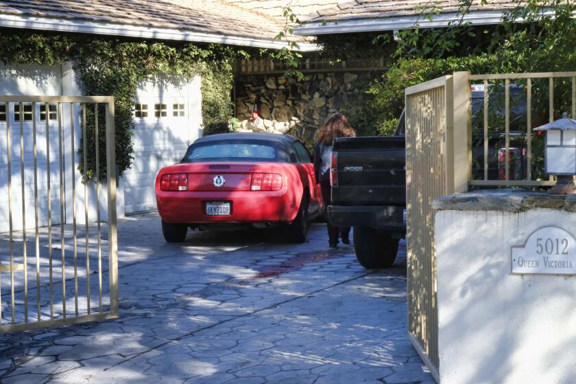 An unknown visitor arrives at a gated house in the Woodland Hills section of Los Angeles on Tuesday, Jan. 24, 2017. Homicide detectives are investigating the death of Fabio Sementilli, an internationally known hairdresser and beauty company executive found beaten and stabbed outside his Los Angeles home. Police say paramedics found Sementilli bleeding profusely Monday afternoon at the gated house in the upscale Woodland Hills neighborhood. The 49-year-old suffered multiple stab wounds and died at the scene. (AP Photo/Richard Vogel)