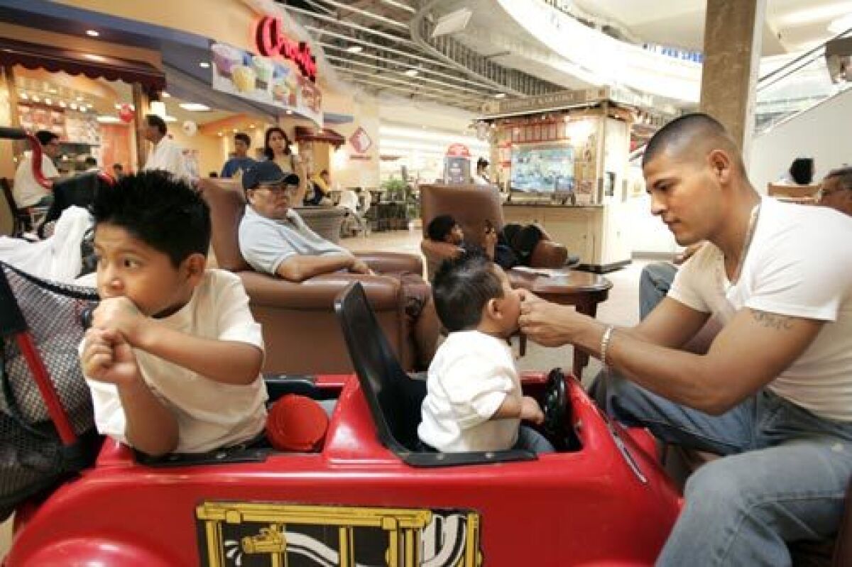 Norwin Navas sits with sons Abraham, 5, and Kenny, 8 months, in the Eagle Rock Plaza mall.