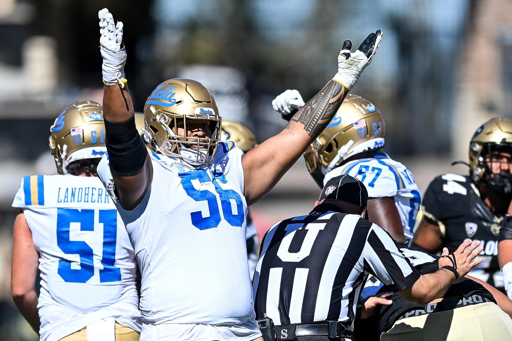 Offensive lineman Atonio Mafi #56 of the UCLA Bruins lifts his arms as a field-goal attempt is good 