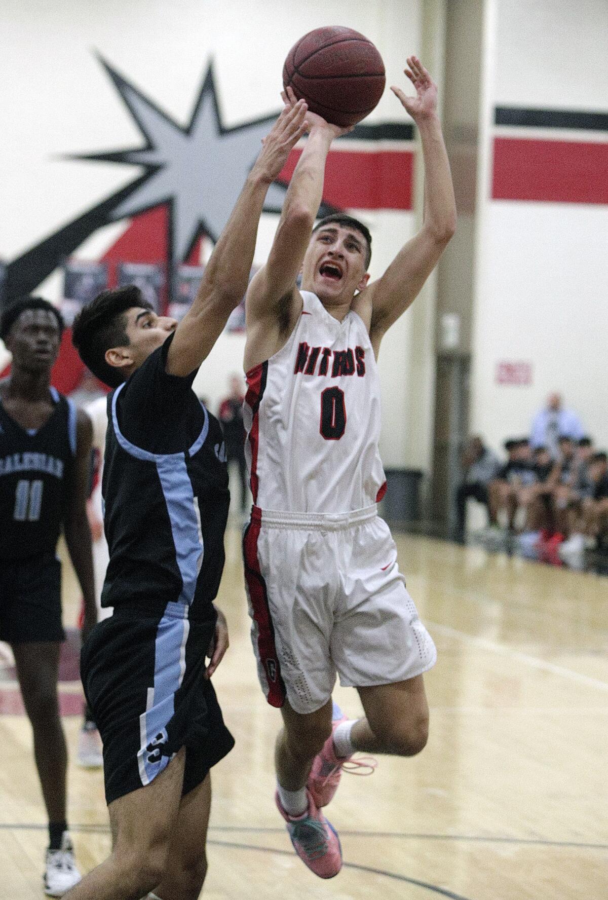 Glendale's Manny Kapoushian drives and shoots, is fouled, and scores against Salesian's Efren Lemus in the CIF Southern Section division III-AAA second-round boys' basketball playoff in at Glendale High School on Friday, February 14, 2020. Salesian won the game in overtime beating Glendale 55-49.