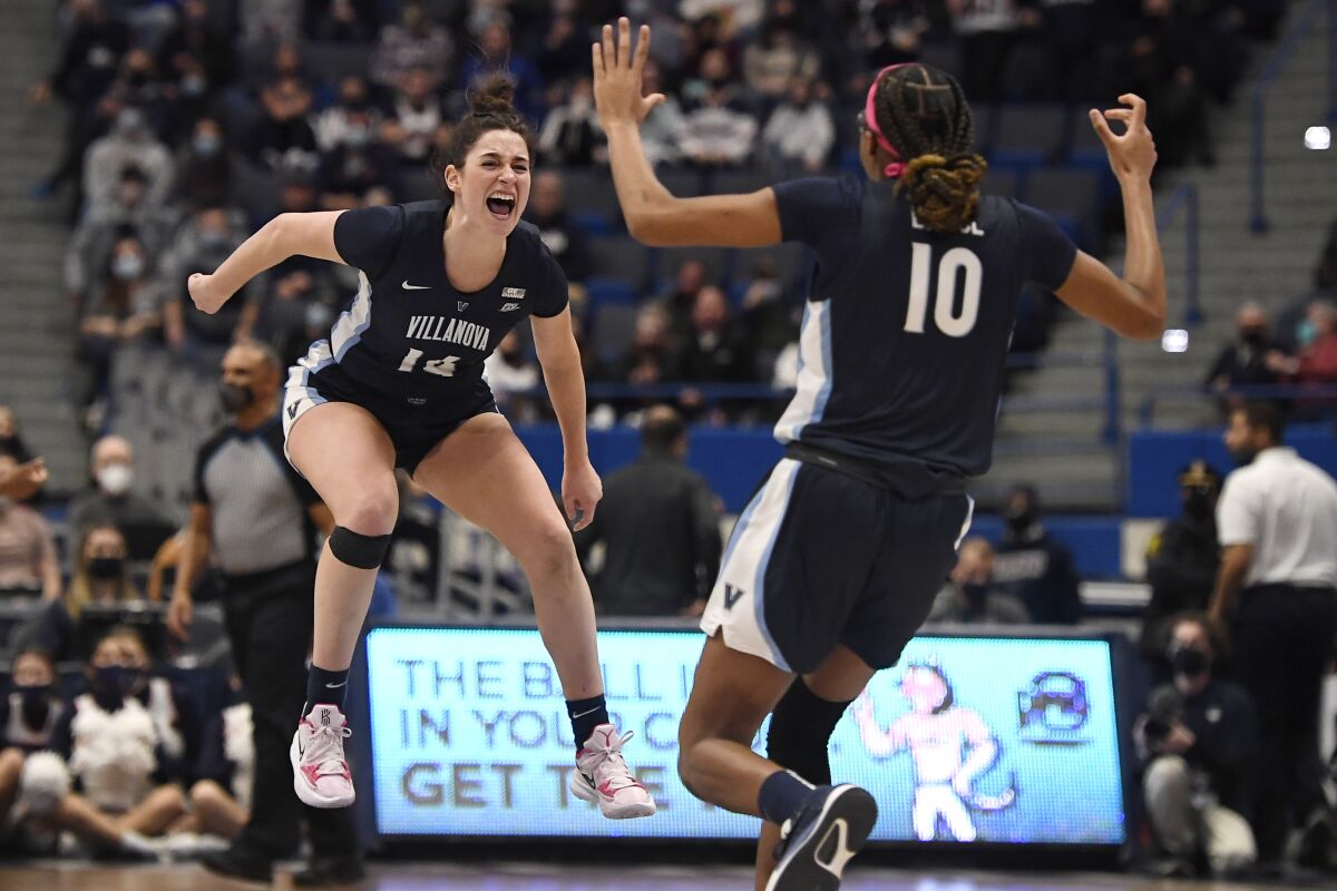 Villanova's Brianna Herlihy (14) and Villanova's Christina Dalce (10) embrace in the air as they celebrate their team's win in an NCAA college basketball game against Connecticut, Wednesday, Feb. 9, 2022, in Hartford, Conn. (AP Photo/Jessica Hill)