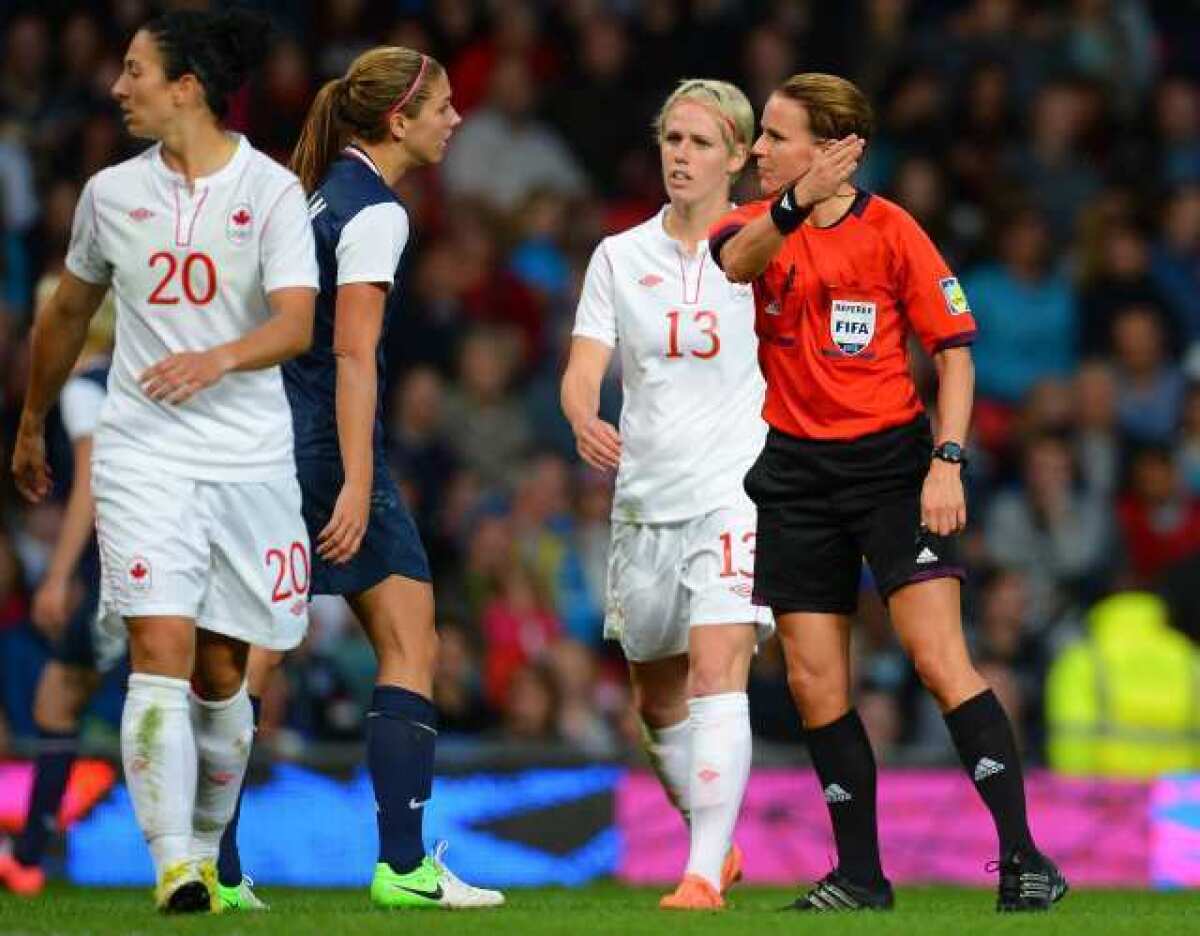 Referee Christina Pedersen, right, speaks to players during Monday's U.S.-Canada women's soccer match.