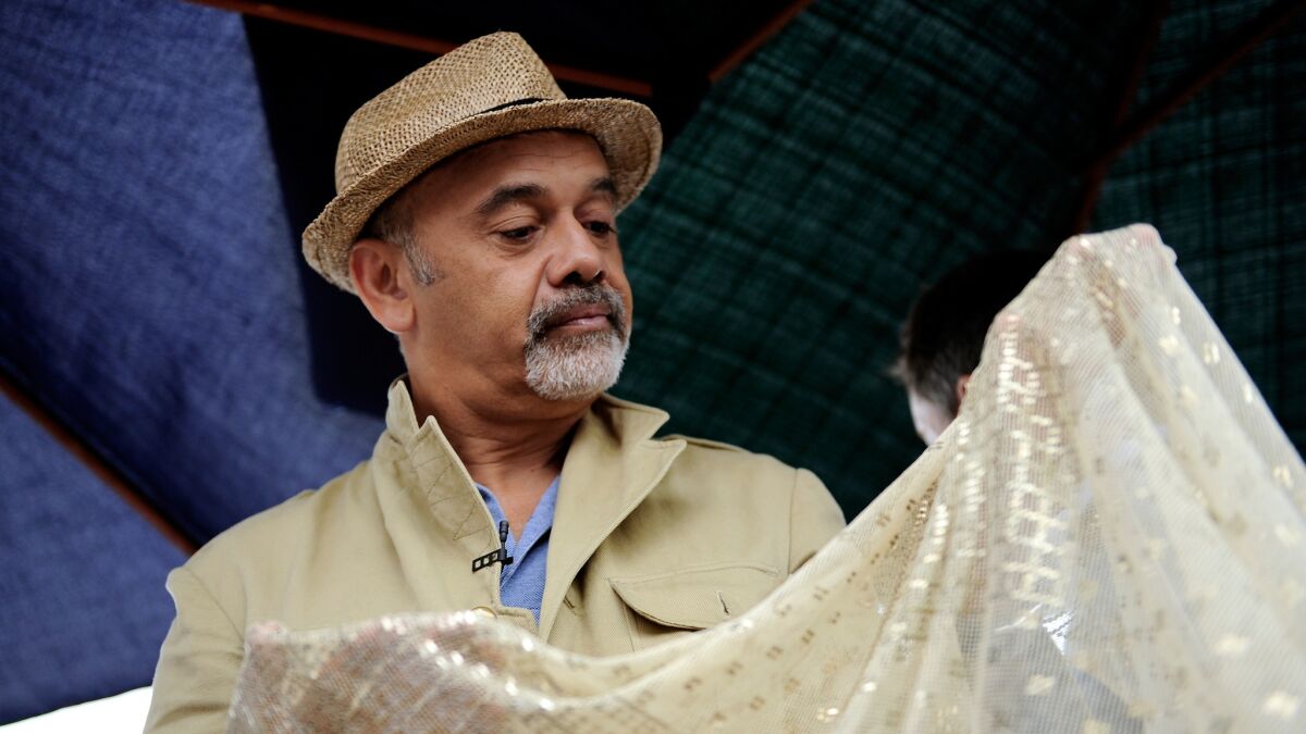 Designer Christian Louboutin looks for inspiration and hidden treasures during a visit to the Rose Bowl flea market.