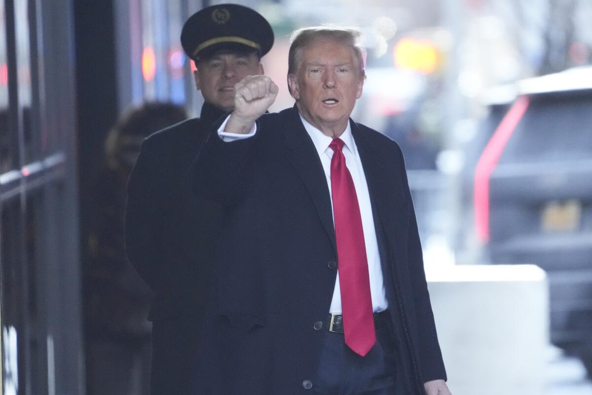 Donald Trump raises a fist outside his New York apartment building. 