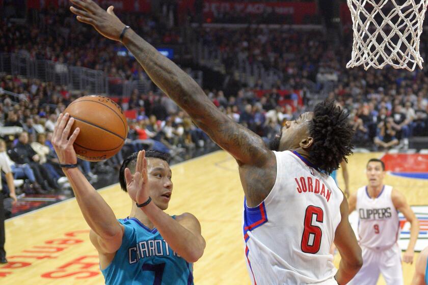 Clippers center DeAndre Jordan forces Hornets guard Jeremy Lin to pass after driving to the basket during a game at Staples Center on Jan. 9.