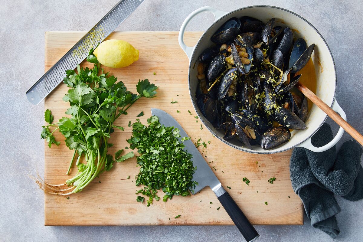 Freshly chopped cilantro and parsley, along with finely grated lemon zest, are added to a meal of mussels with white beans.
