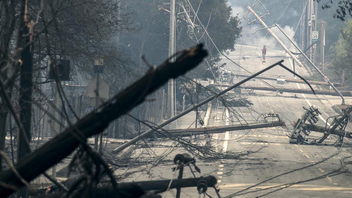 Power poles and lines block a street at Brookdale and Aaron Drive in Hidden Valley, where most of the homes were destroyed by fire in Santa Rosa.