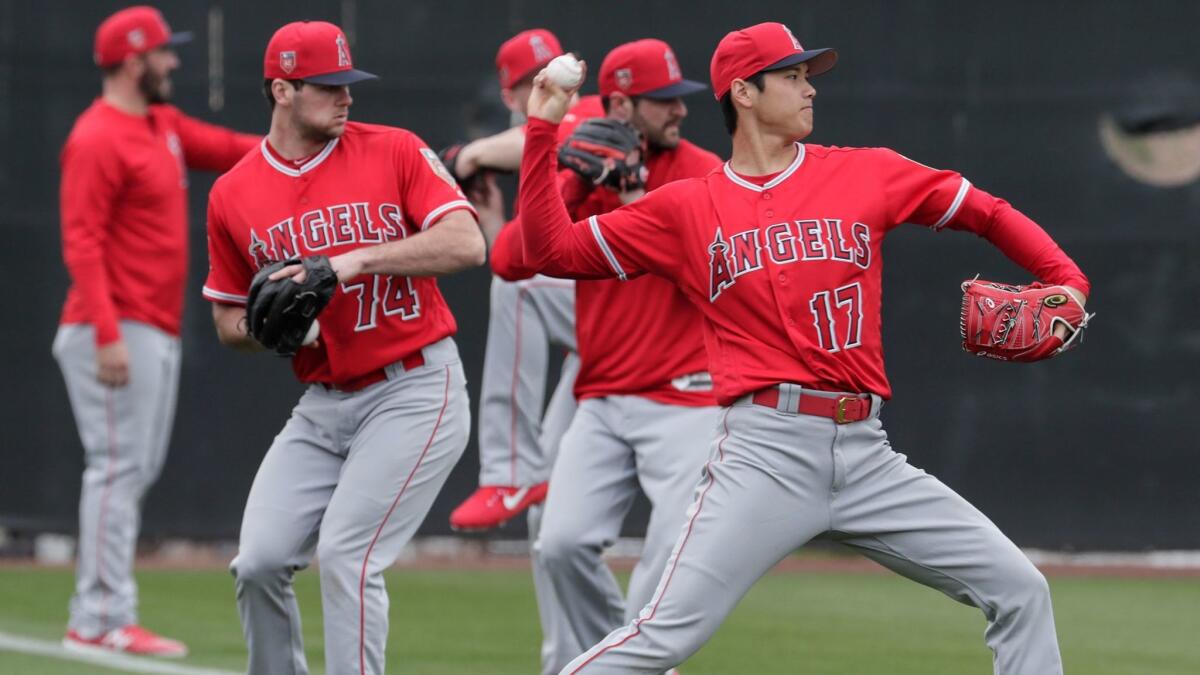 Shohei Ohtani warms up with other pitchers during his first day of spring training.