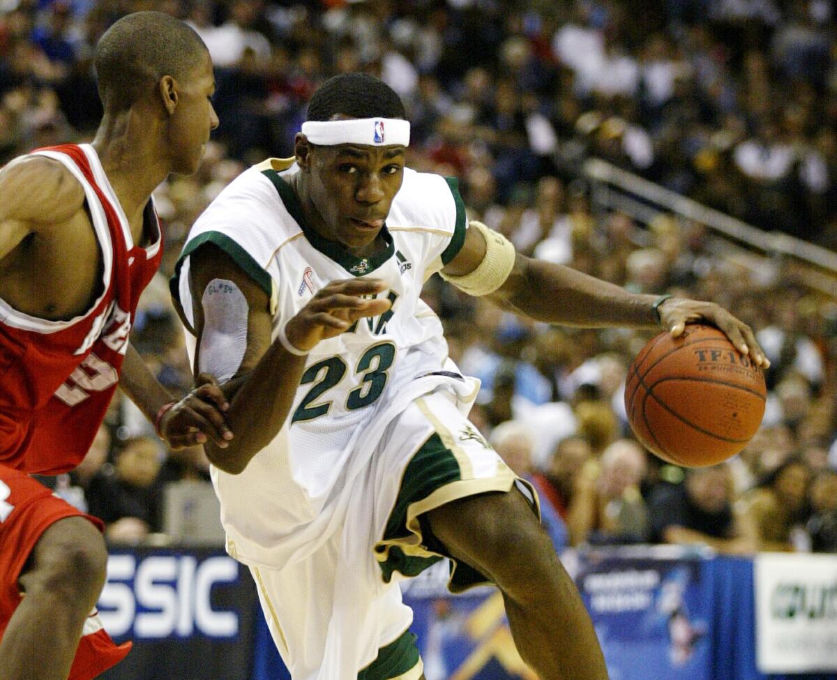 St. Vincent St. Mary's LeBron James drives against Mater Dei's D.J. Strawberry during a game at Pauley Pavilion.
