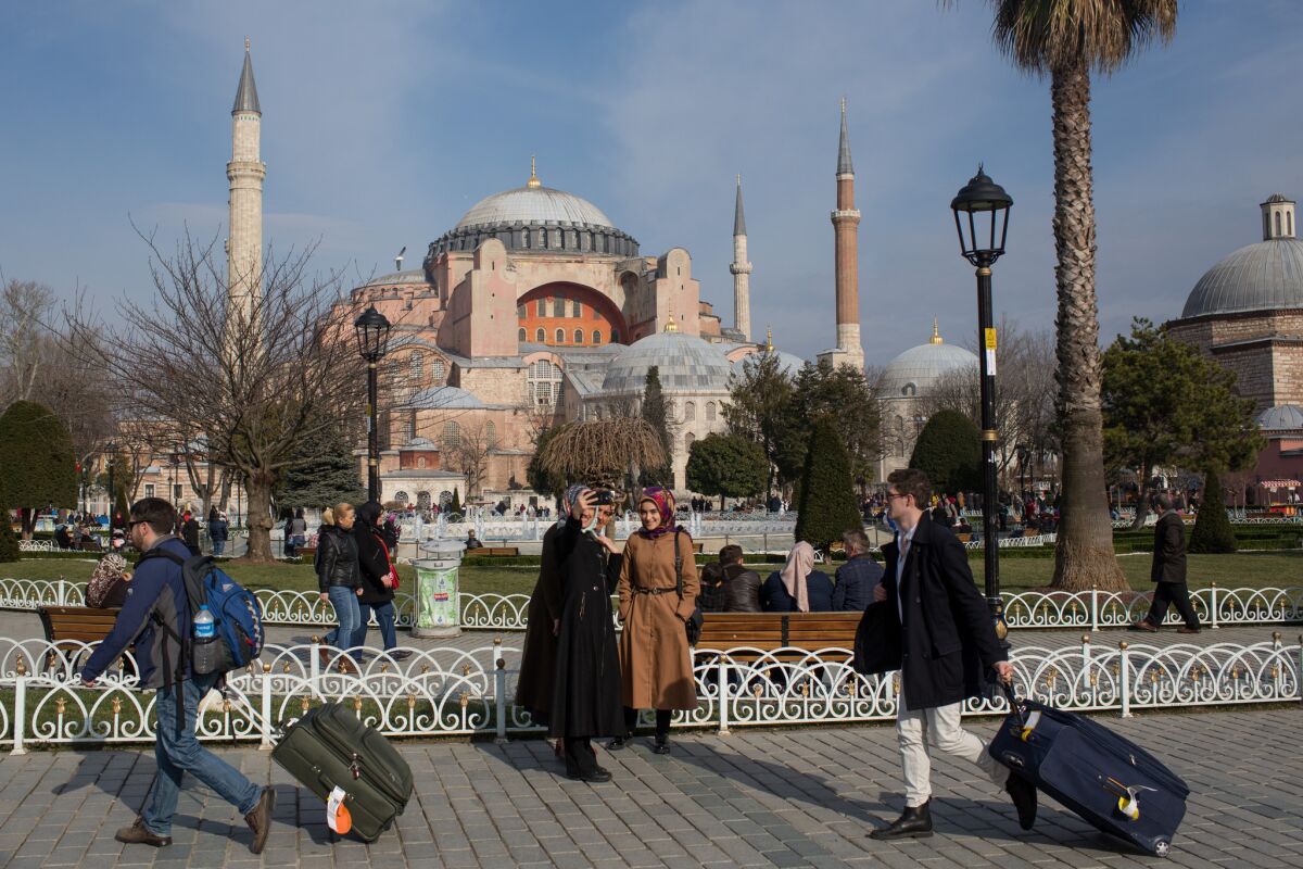 Tourists walk past the Hagia Sophia in Istanbul in a photo taken before the COVID-19 pandemic.