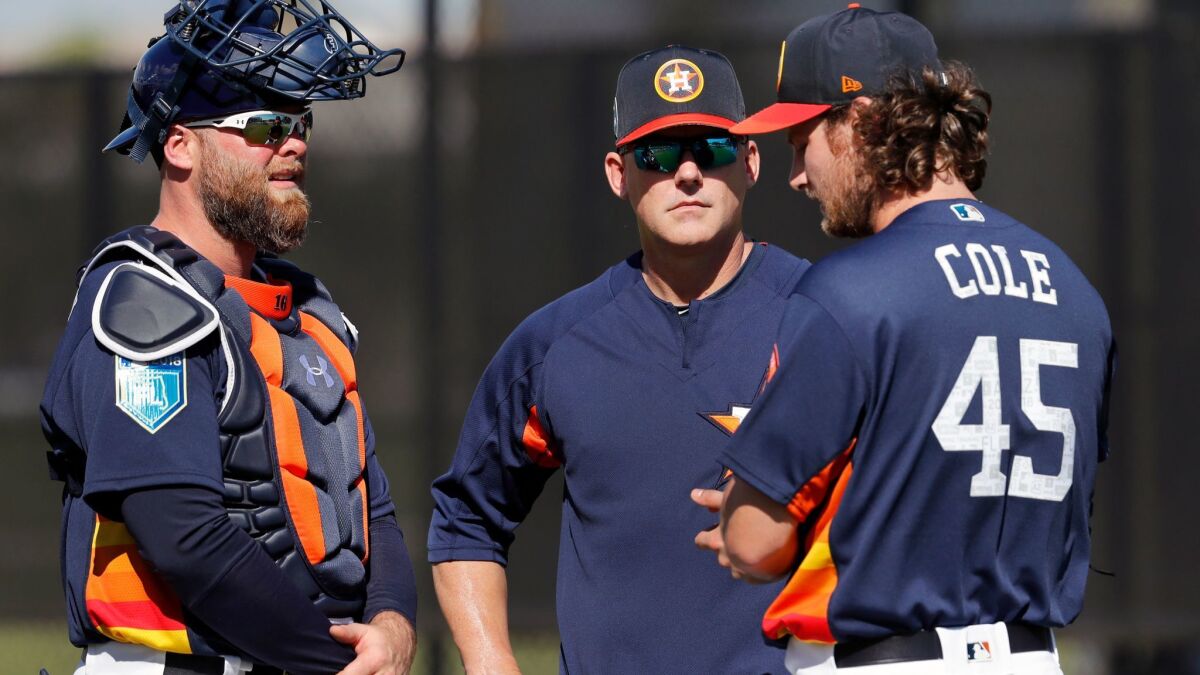 Astros pitcher Gerrit Cole (45) talks with manager A.J. Hinch and catcher Brian McCann, left, after throwing a bullpen session during spring training baseball practice Thursday, Feb. 15, 2018, in West Palm Beach, Fla.