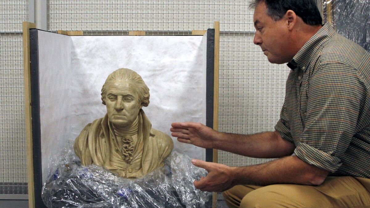 R. Scott Stephenson, vice president of collections, exhibitions and programming, shows a terra cotta and plaster bust of George Washington, made by William Rush in 1817.
