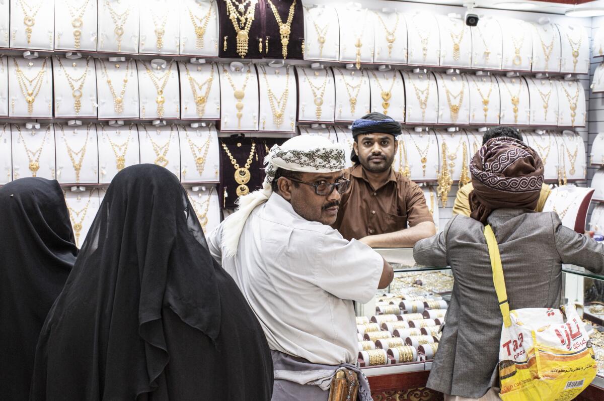 A family buys traditional Yemeni jewelry at a gold shop in the market area of Ataq in Shabwa province, Yemen.