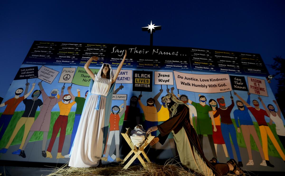 Claremont United Methodist Church's Nativity scene shows Mary, Joseph and baby Jesus in front of people wearing masks