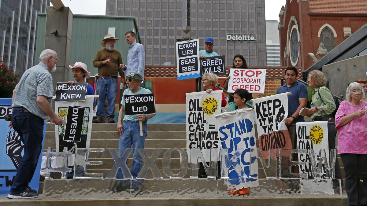 People protest outside an Exxon Mobil annual shareholder meeting in Dallas.