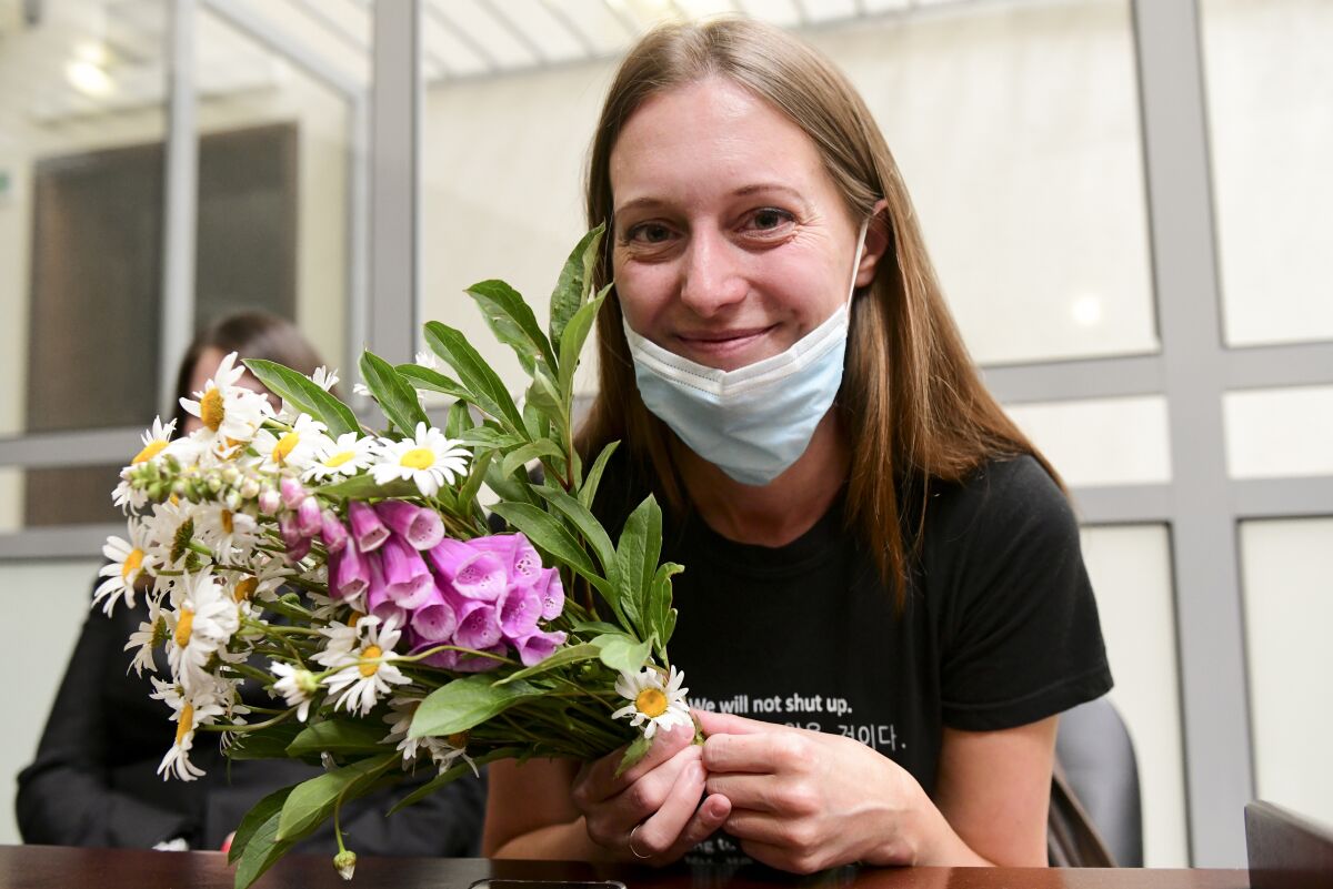 Russian journalist Svetlana Prokopyeva holds a bunch of flowers after a court session in Pskov, Russia, Monday, July 6, 2020. A court in the city of Pskov convicted Prokopyeva on charges of condoning terrorism on Monday and ordered her to pay a fine in a case that has been widely criticized as an attack on freedom of speech. (AP Photo)