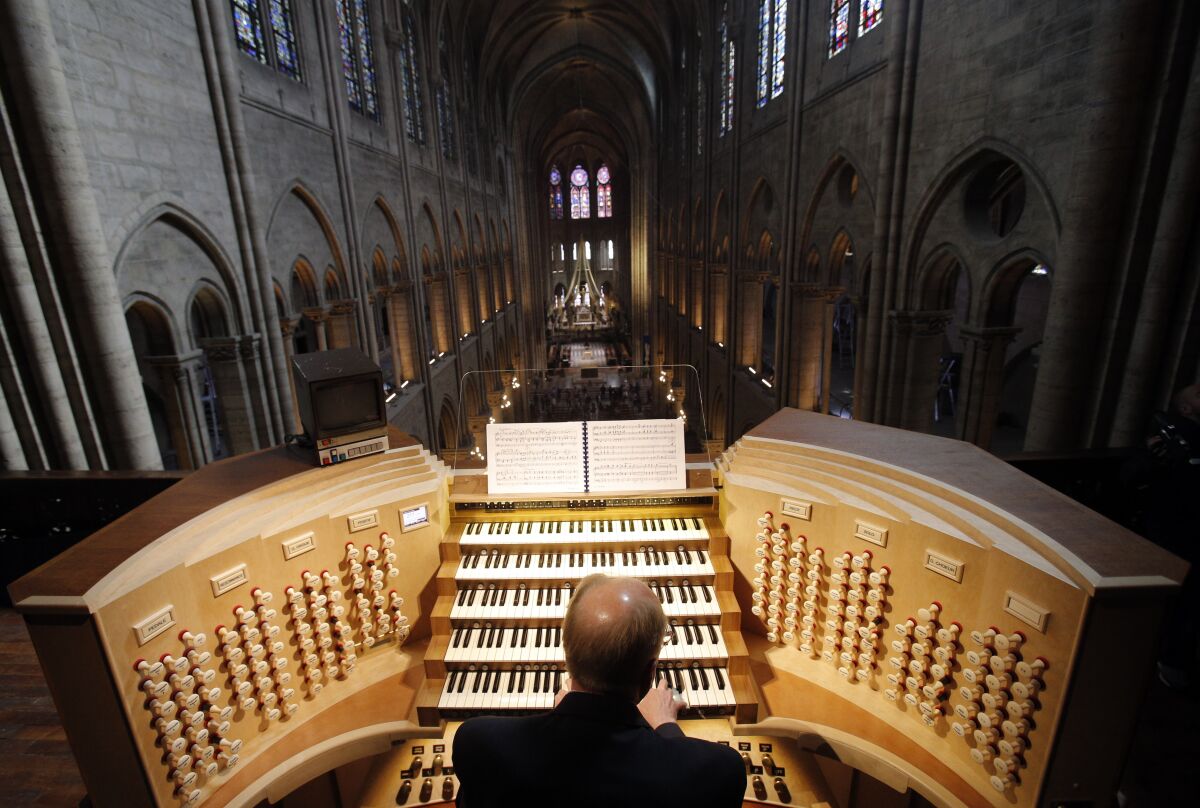 FILE - In this Thursday, May 2, 2013 file photo, Philippe Lefebvre, 64, plays the organ at Notre Dame cathedral in Paris. Pipe by precious pipe, the organ that once thundered through fire-ravaged Notre Dame Cathedral is being taken apart. The mammoth task of dismantling, cleaning and re-assembling France's largest musical instrument started Monday Aug.3, 2020 and is expected to last nearly four years. (AP Photo/Christophe Ena, file)