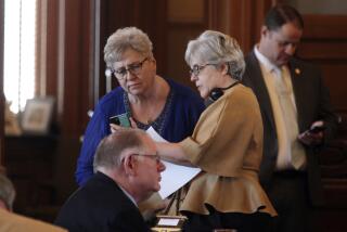 Kansas House Health and Human Services Committee Chair Brenda Landwehr, left, R-Wichita, consults with Majority Whip Susan Estes, right, also R-Wichita, during the House's session, Wednesday, March 6, 2024, at the Statehouse in Topeka, Kan. Landwehr and other anti-abortion lawmakers are pursuing a bill to require providers to ask their patients why they are having abortions and to report their answers to the state. (AP Photo/John Hanna)