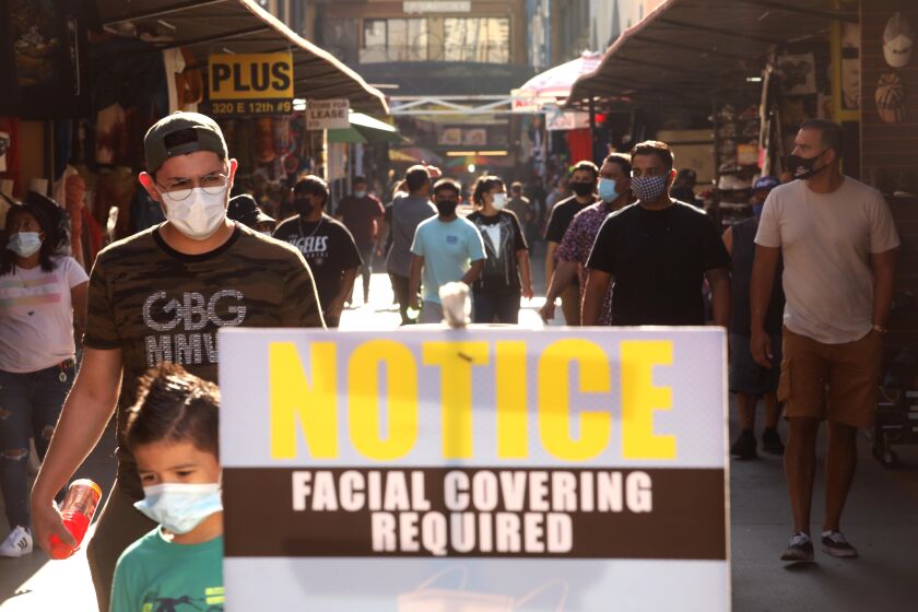 LOS ANGELES, CA - NOVEMBER 04, 2020 - Shoppers make their way along Santee Alley in downtown Los Angeles on November 4, 2020. The Los Angeles City Council voted today to give authority to business owners to refuse service to patrons who do not wear masks or face coverings while on their premises amid the COVID-19 pandemic "Small business owners and their employees are risking their lives to stay afloat in the midst of this economic and public health crisis,'' said Councilman Herb Wesson, who authored the proposed requirement in July. "Wearing a mask saves lives, and this simple, common-sense law will save lives and allow us to beat this virus sooner rather than later.'' (Genaro Molina / Los Angeles Times)