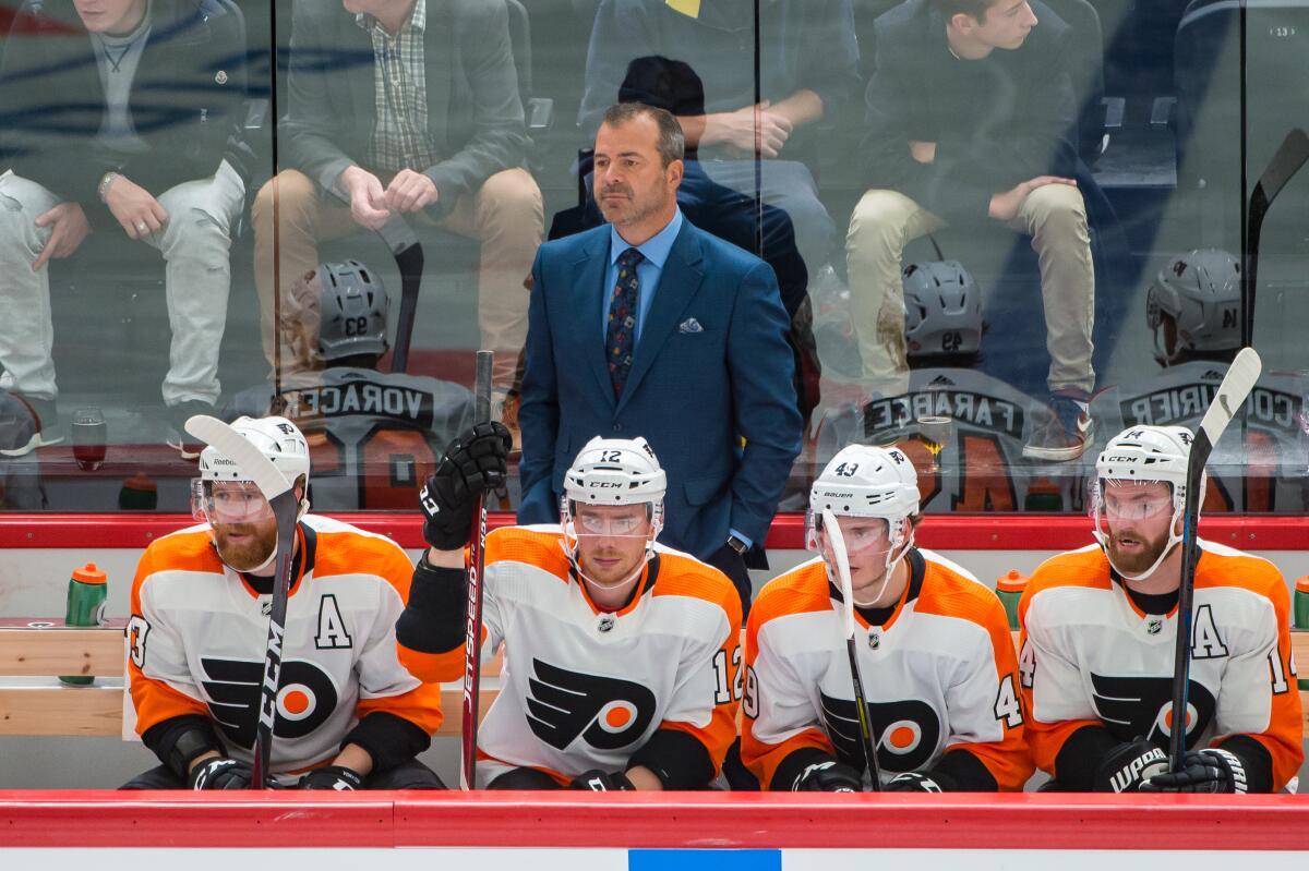 Philadelphia Flyers coach Alain Vigneault stands behind the bench.