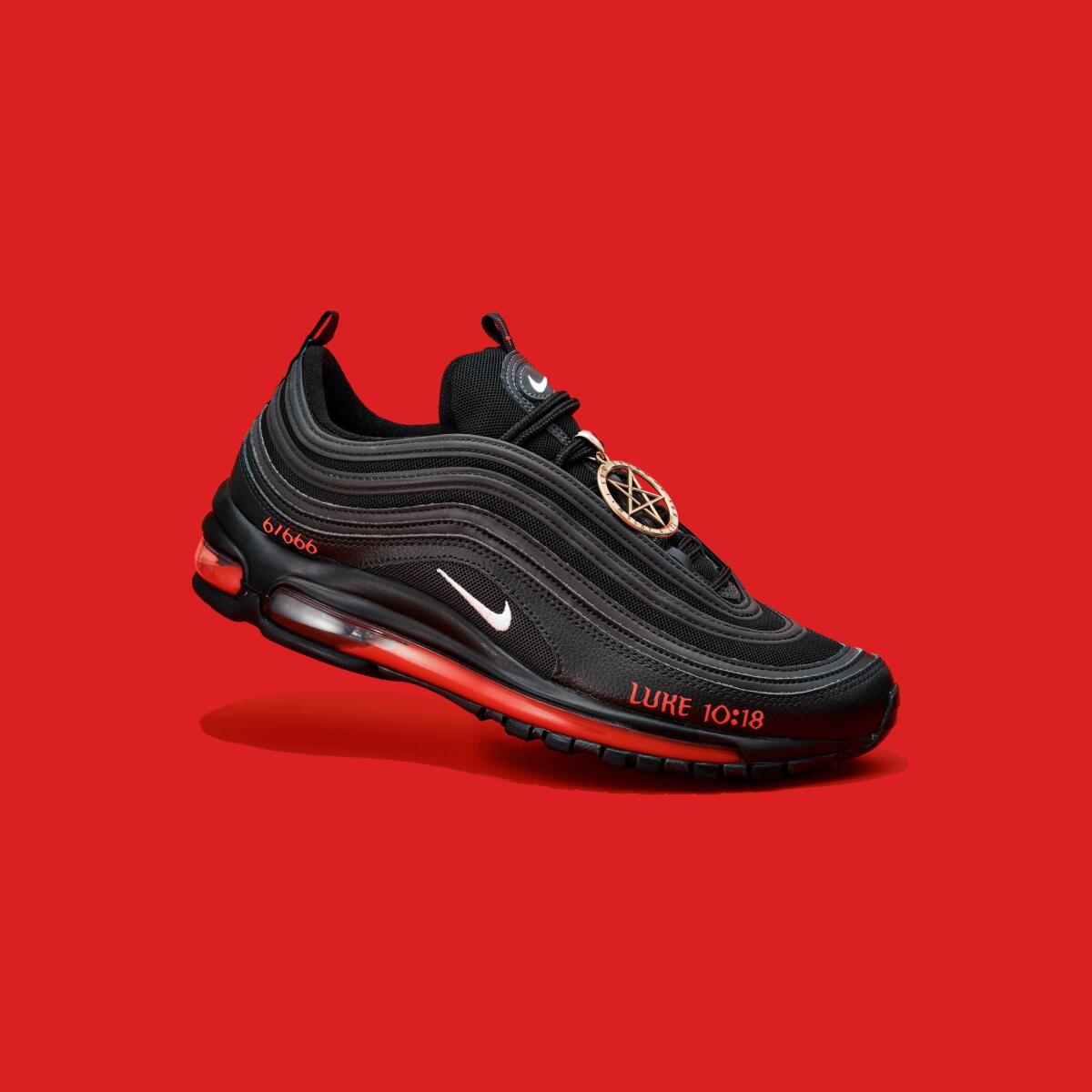 A single black "Satan Shoe" in front of a red background