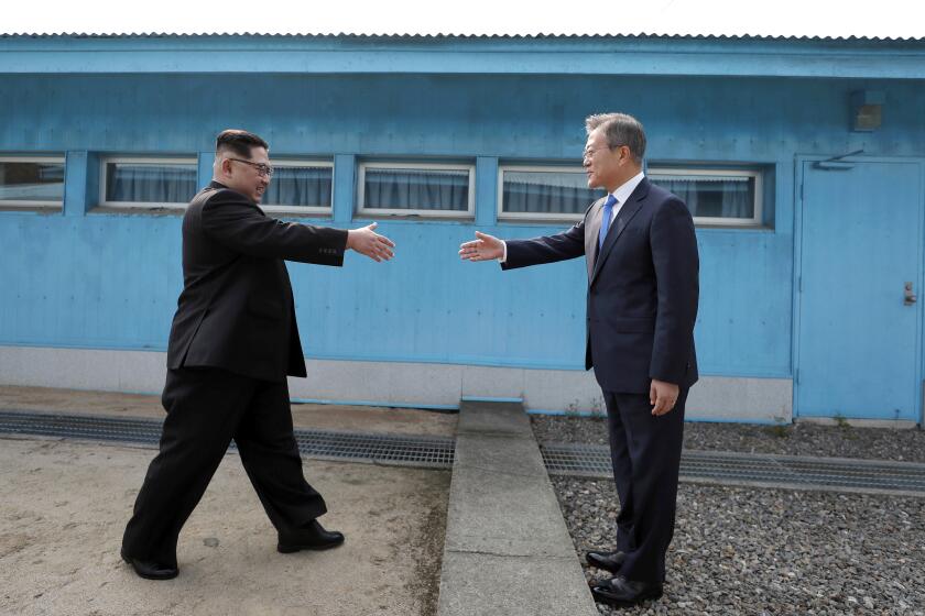 FILE - In this April 27, 2018, file photo, North Korean leader Kim Jong Un, left, prepares to shake hands with South Korean President Moon Jae-in over the military demarcation line at the border village of Panmunjom in Demilitarized Zone. On Friday, Nov. 3, 2023, The Associated Press reported on stories circulating online incorrectly claiming a new video shows a historic meeting between the leaders of North Korea and South Korea at their border, but the mainstream media isn’t covering it. (Korea Summit Press Pool via AP, File)