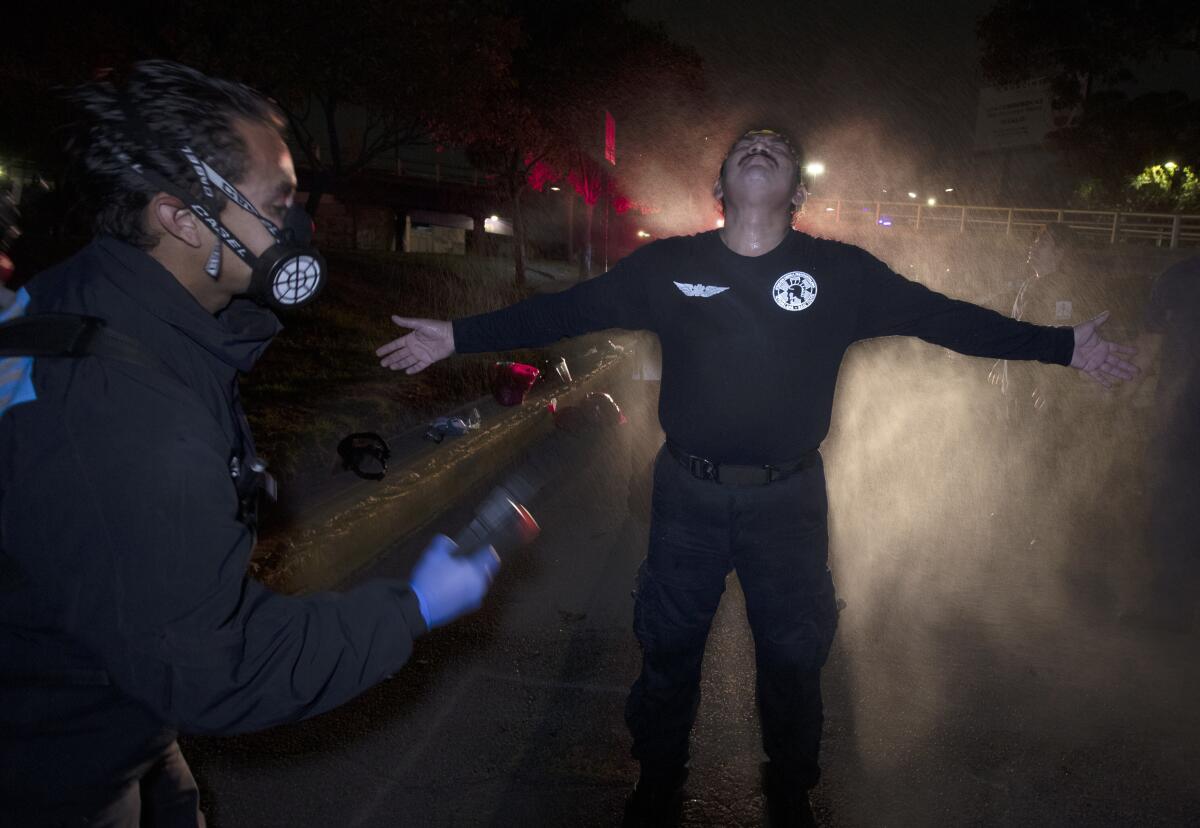 A paramedic coordinator decontaminates a fellow paramedic in Mexico City.