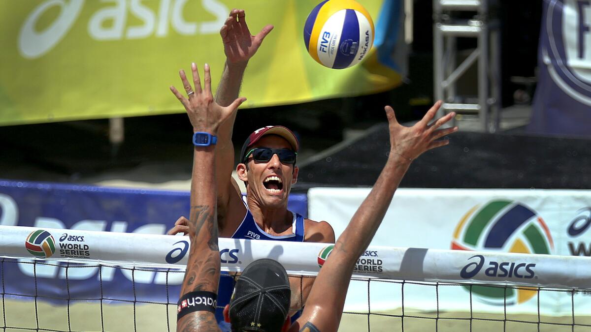 Nick Lucena, who was not happy that he and partner Phil Dalhausser had to play three matches Friday, spikes the ball past Clemens Doppler during a match Thursday at the World Series of Beach Volleyball.