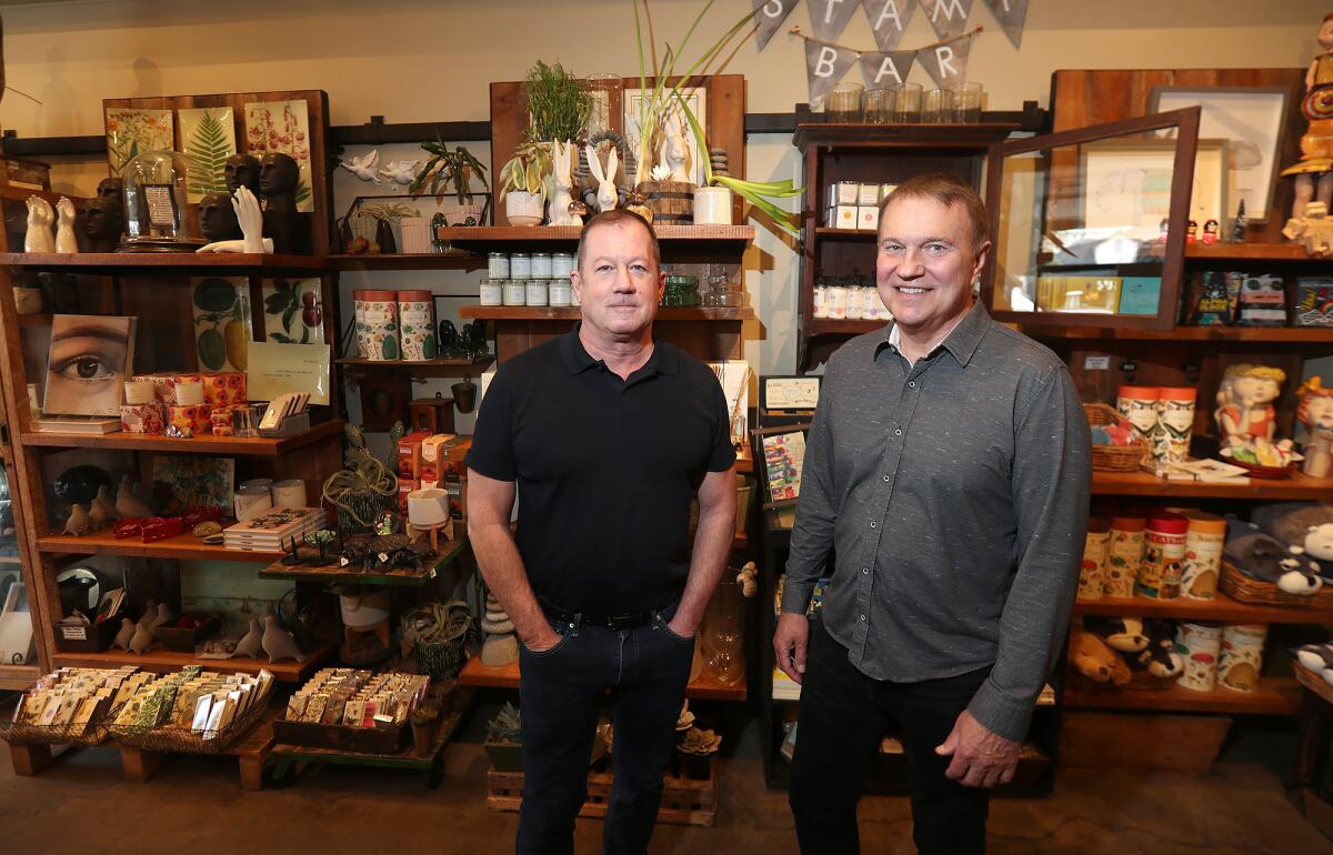 Longtime owners Dave Thomas and Kevin Mundt, from left, stand in front of gifts in AREO in downtown Laguna Beach.
