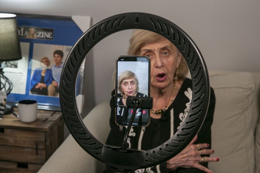 Holocaust survivor Tova Friedman, 85, prepares to record a TikTok video with her grandson, 17-year-old Aron Goodman, in Morristown, New Jersey, on Monday, March 13, 2023. Goodman records TikTok videos of his grandmother describing her experiences as a six-year-old at Auschwitz concentration camp that have millions of views on the social media platform. (AP Photo/Ted Shaffrey)